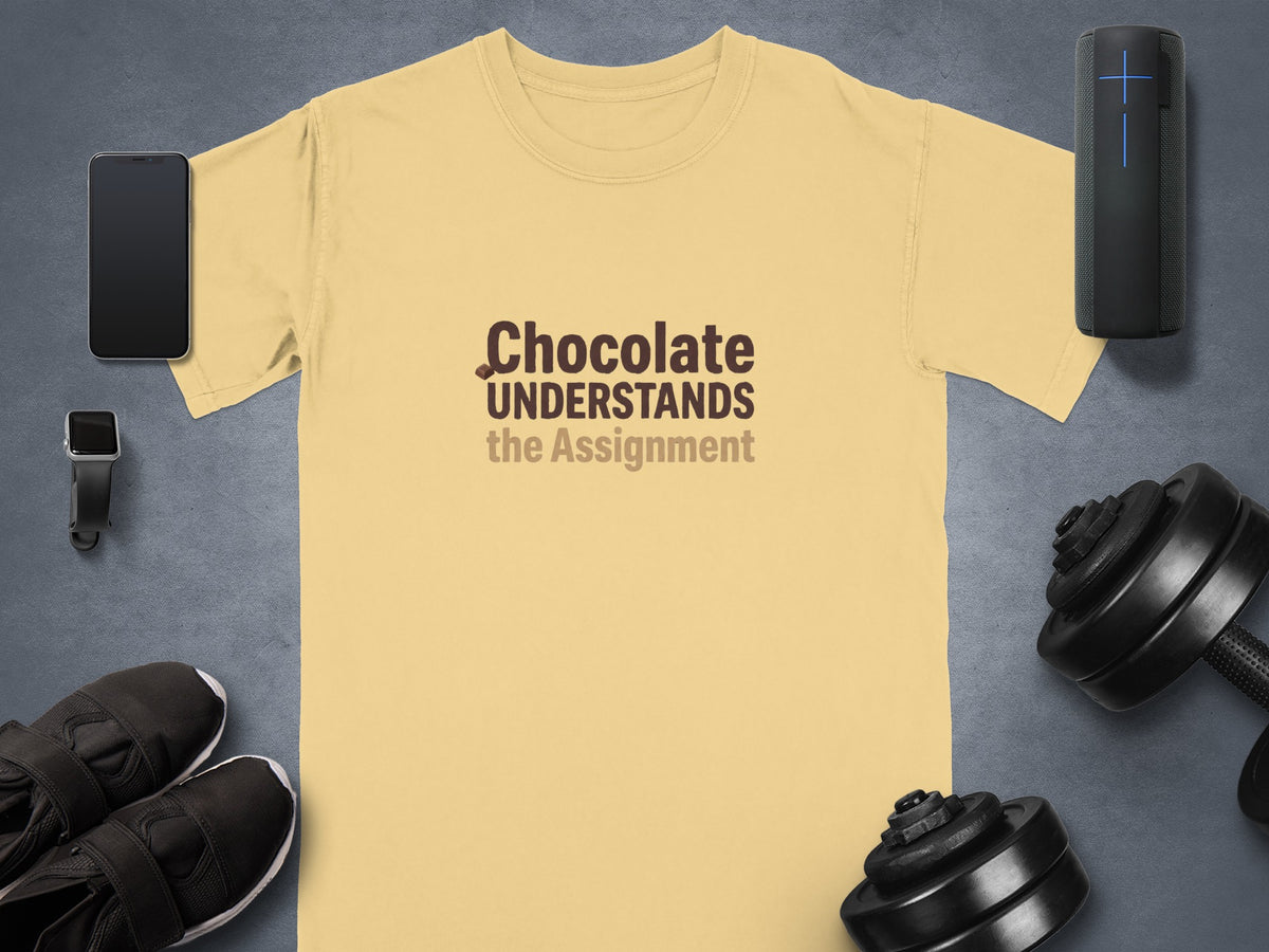 Yellow t-shirt with "Chocolate UNDERSTANDS the Assignment" text and gym accessories.