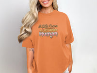 Orange t-shirt with dripping text "A Little Cocoa A Lot More Human".
