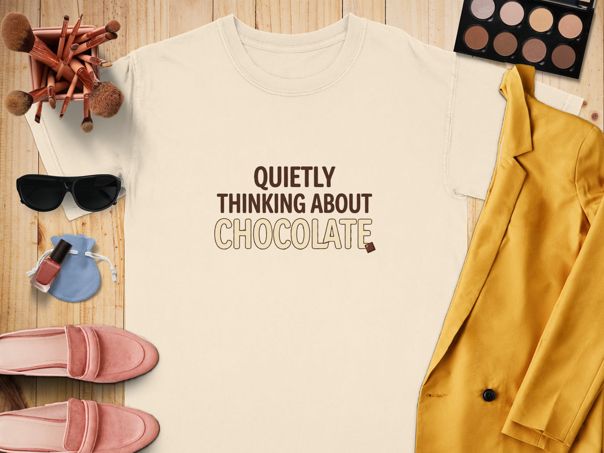 Cream t-shirt with "QUIETLY THINKING ABOUT CHOCOLATE" text and chocolate piece.