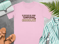 Pink t-shirt with "I'd rather be home tempering chocolate" text.