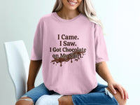 Pink t-shirt with chocolate stain graphic and "I Came. I Saw. I Got Chocolate on My Shirt." text.