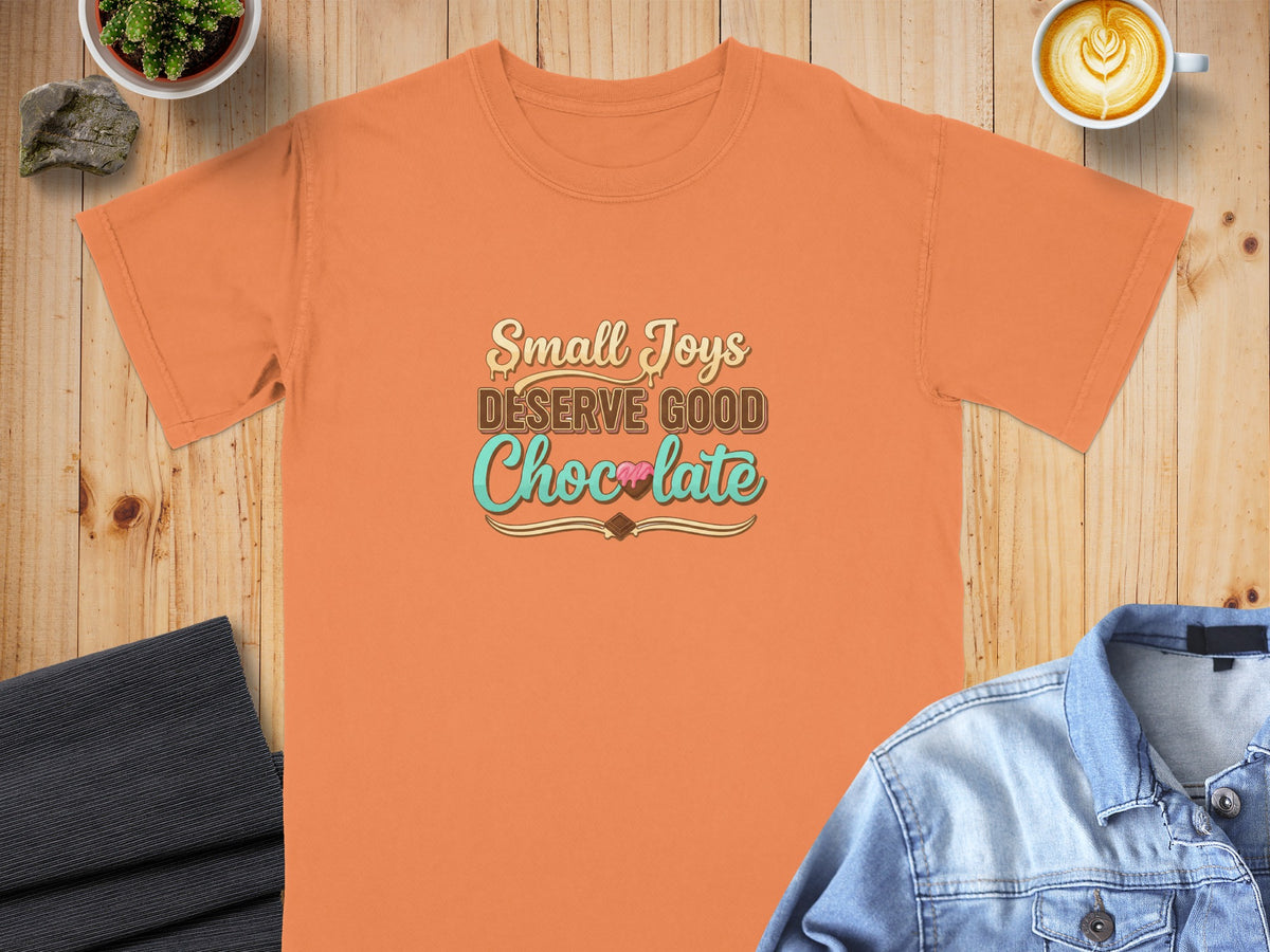 Orange t-shirt with "Small Joys DESERVE GOOD Chocolate" text and chocolate bar graphic.